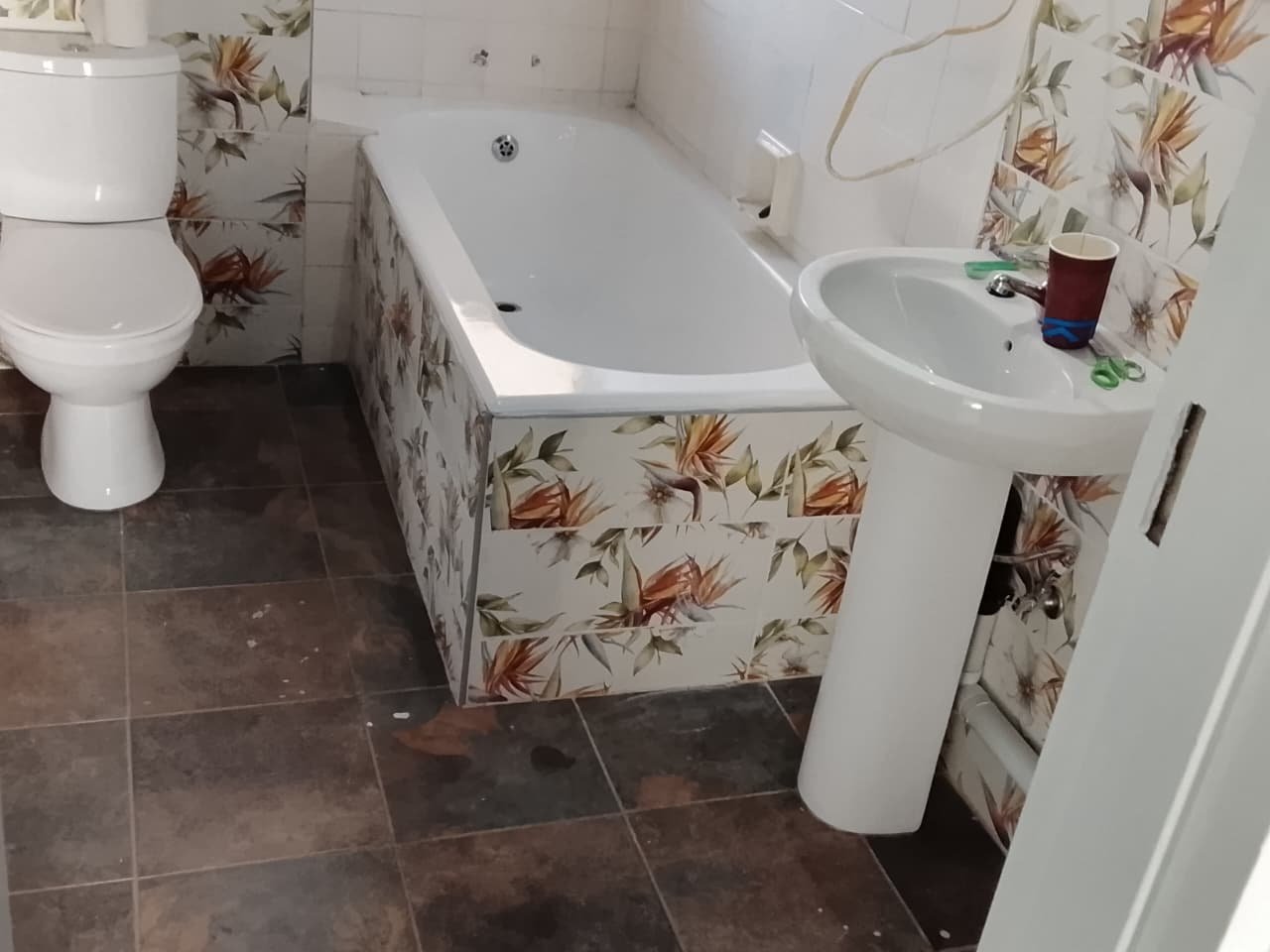 Fully tiled bathroom with bath, basin and patterned feature tiles
