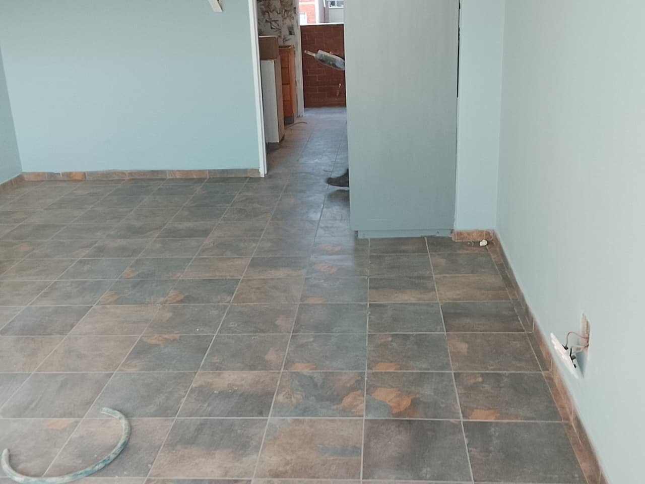 Newly tiled living area floor with matching skirting tiles